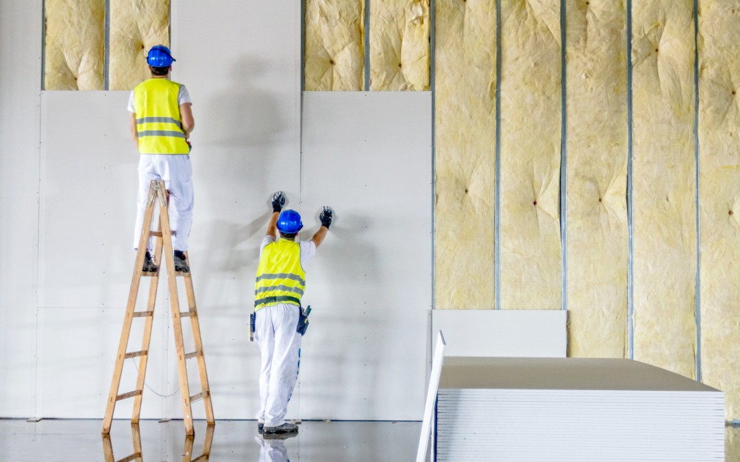 Operario trabajando en la instalación de placas de yeso sobre estructura de perfiles